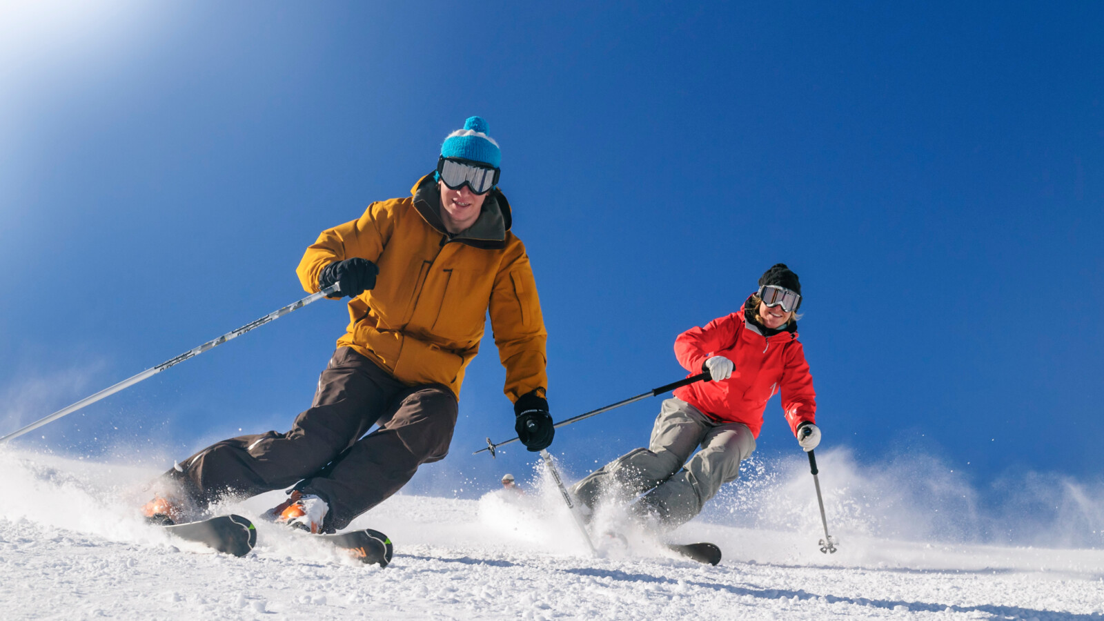 Zwei Skifahrer carven synchron auf der Piste